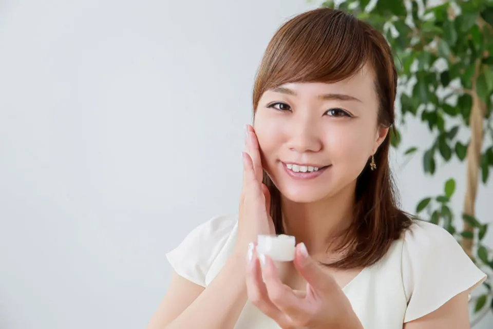 保湿クリームをつける女性の写真