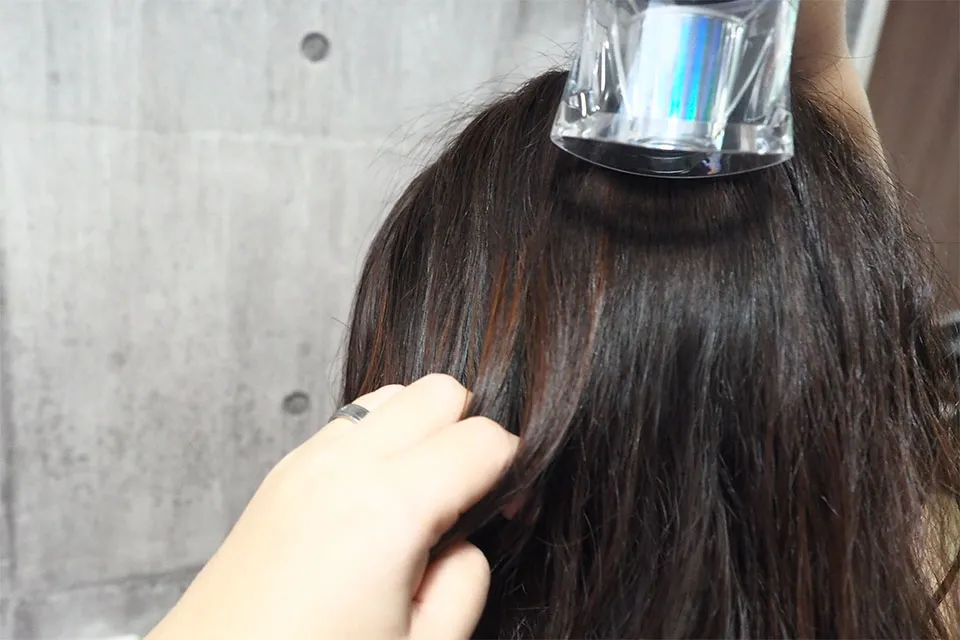 ドライヤーで髪を乾かしている画像