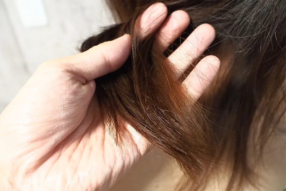 毛先にヘアオイルを重ね付けする