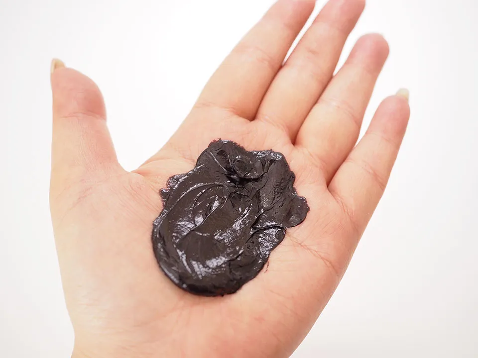 黒クリームシャンプーを手に広げている写真