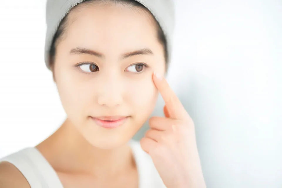 目元を気にする女性の写真