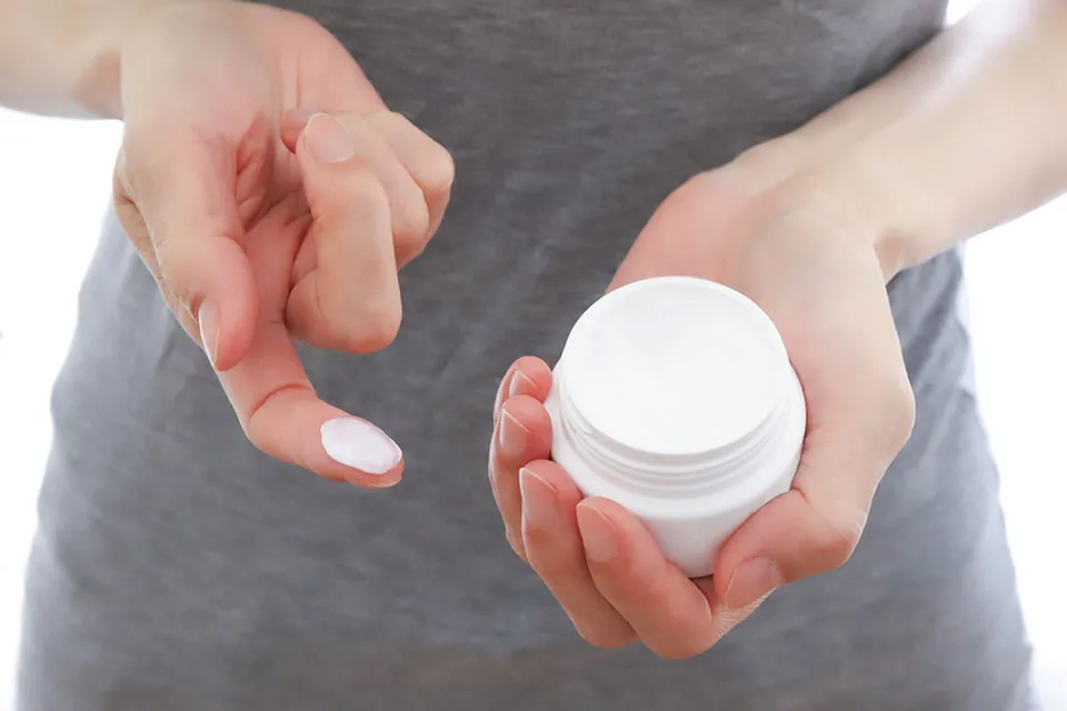 クリームを指に取る女性の写真