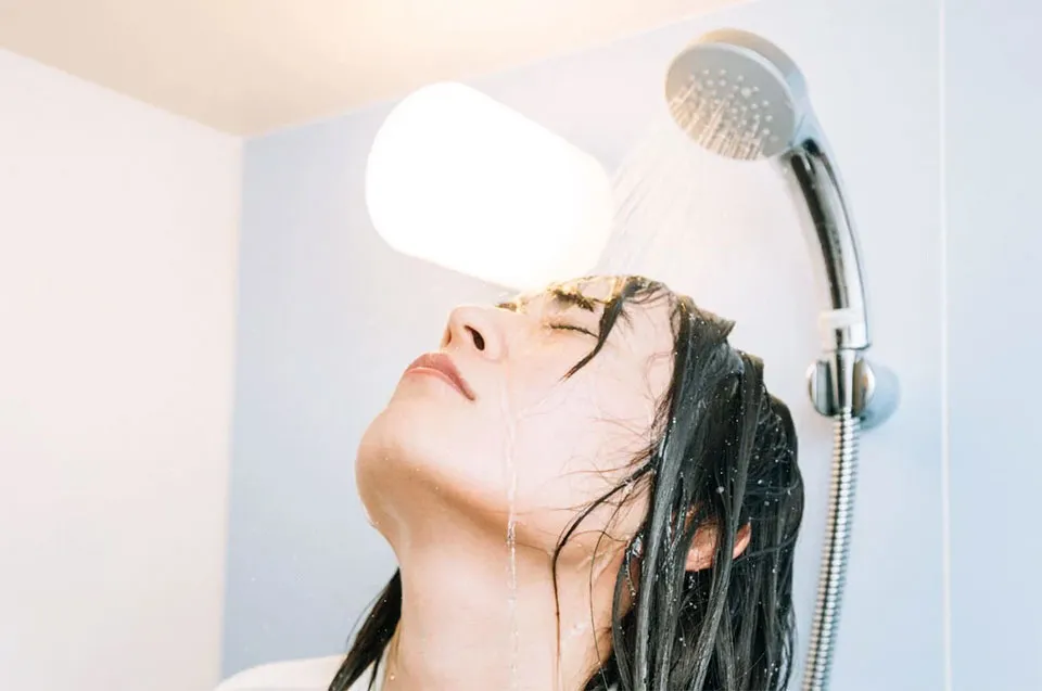 シャワーを浴びるときに上を向く人の写真