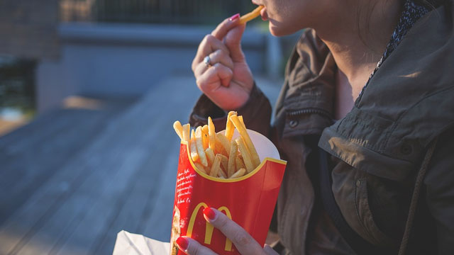 ポテトを食べる女性