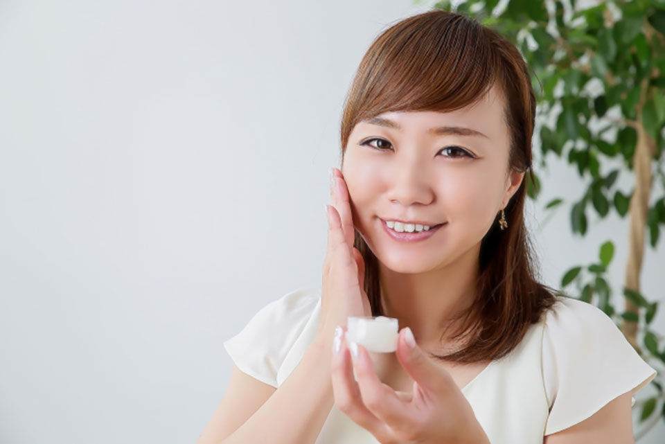保湿クリームをつける女性の写真