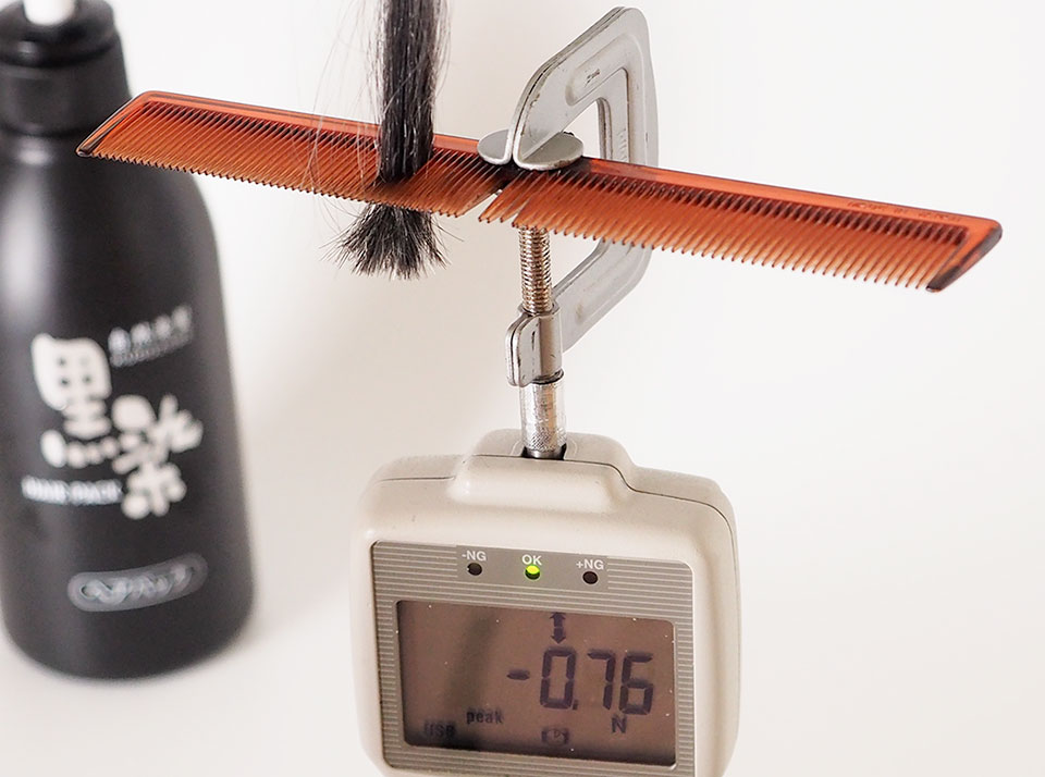 黒染ヘアパックでの染毛白髪をデジタルフォースゲージで測定中