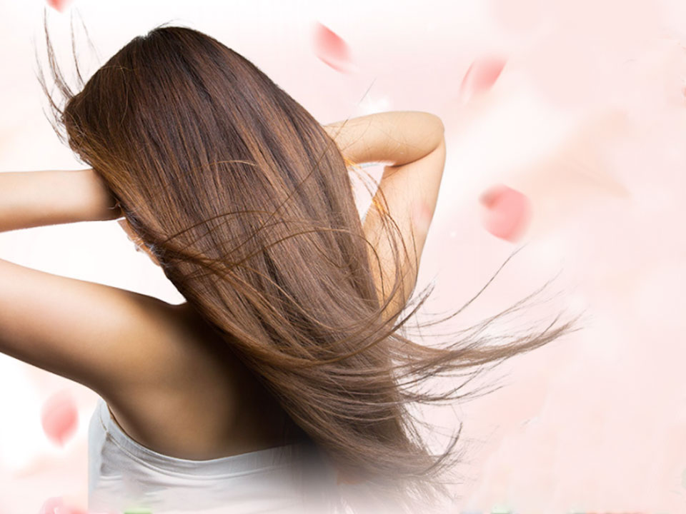 髪をかきあげている女性の画像