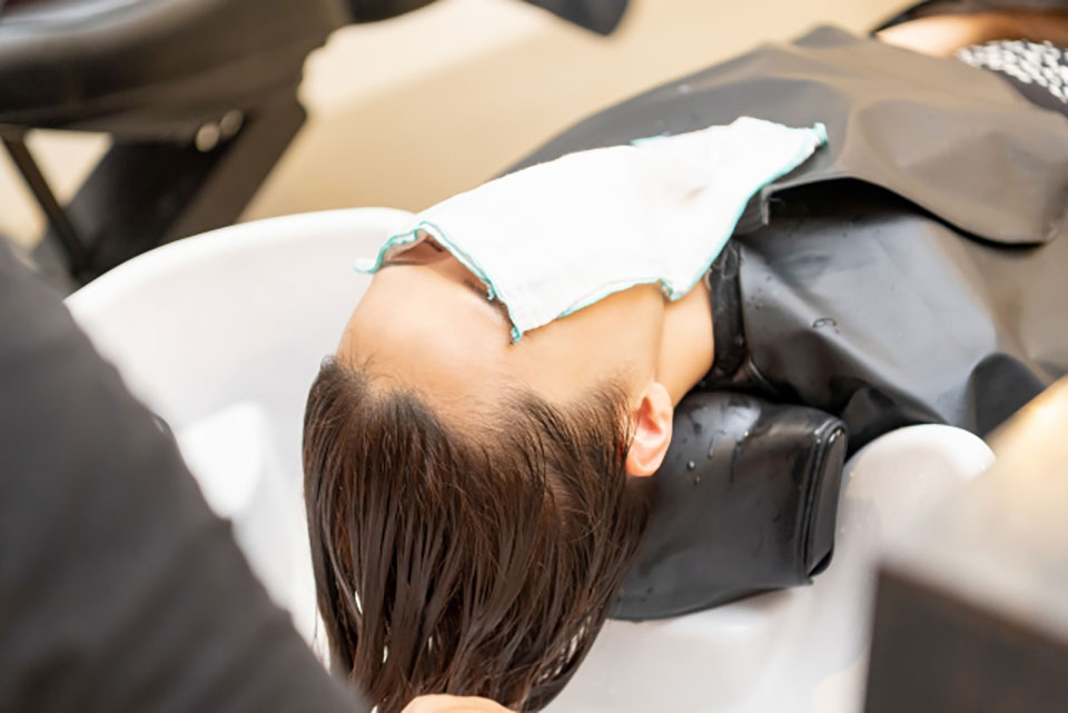 美容室のシャンプー台にいる女性の画像